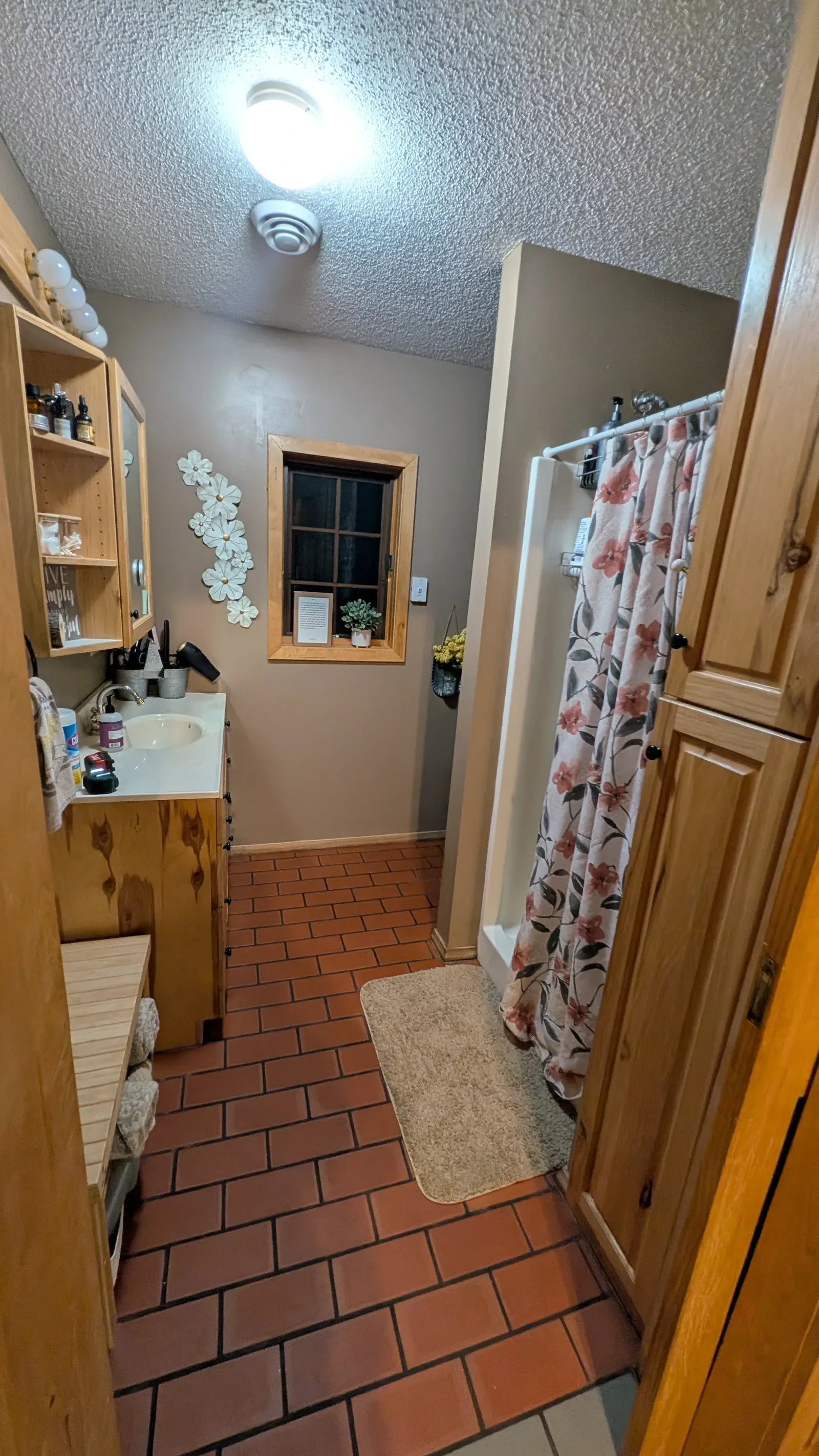 Original bathroom showing brick tile floor and pine cabinet