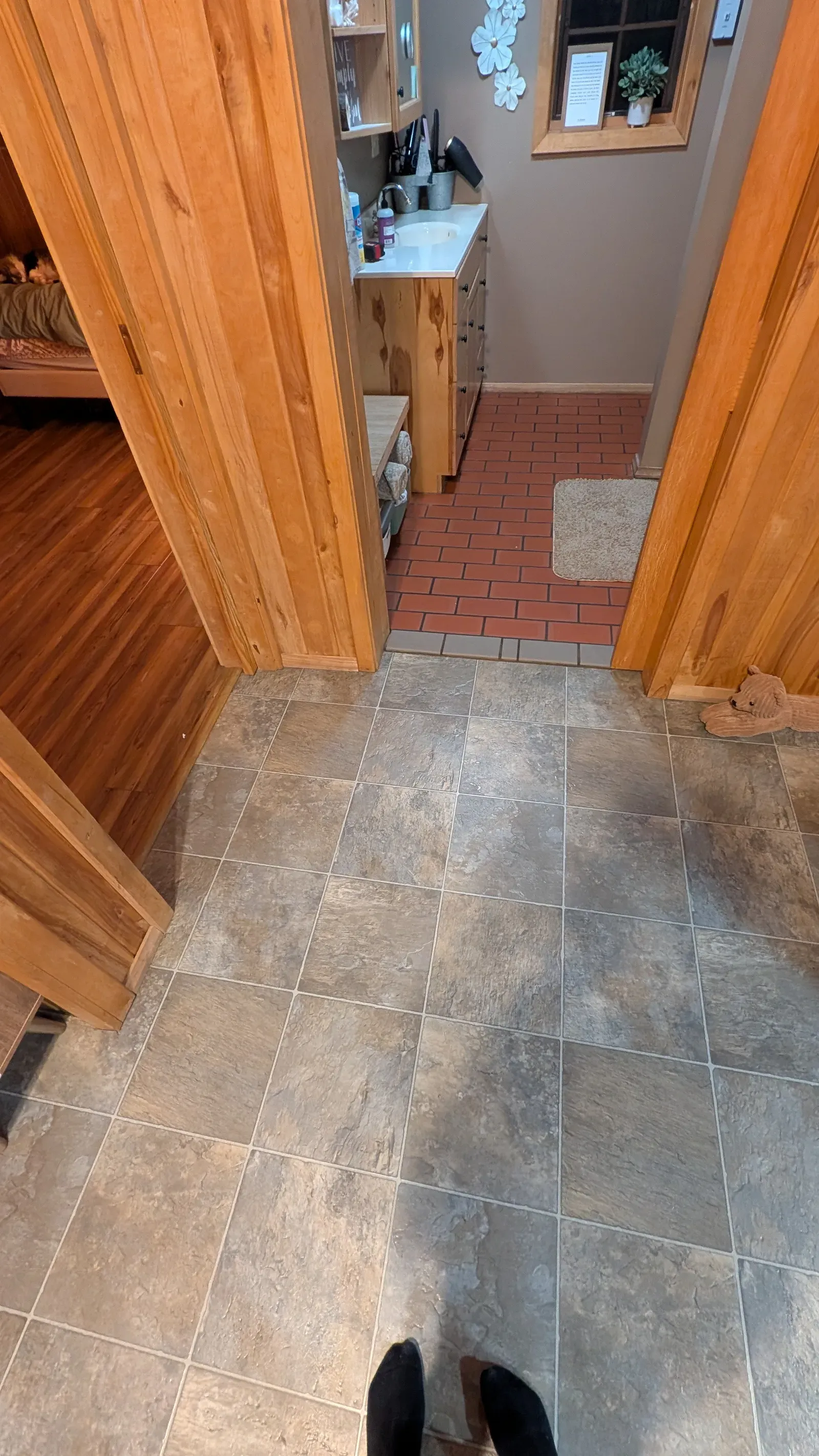 Hallway transition showing old floor tile leading into bathroom