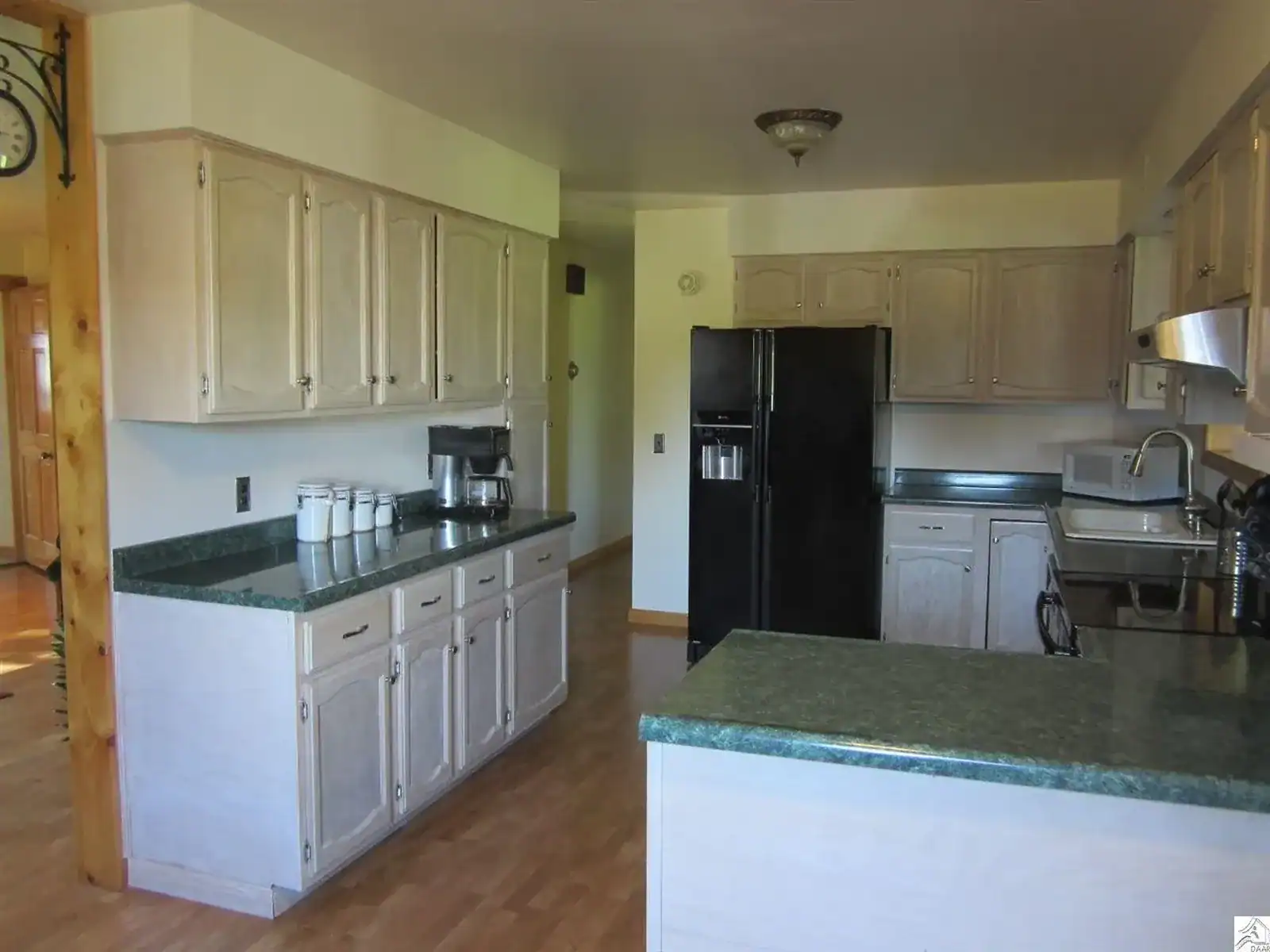 Kitchen before renovation showing dated cabinets and layout