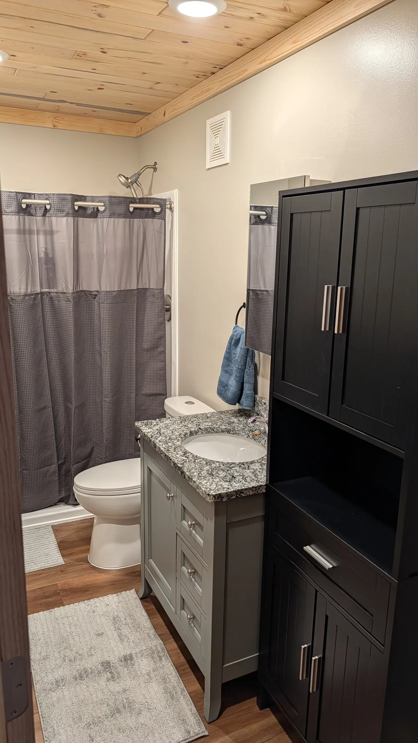 Renovated bathroom with new vanity, storage cabinet, tub/shower combo, and LVP flooring