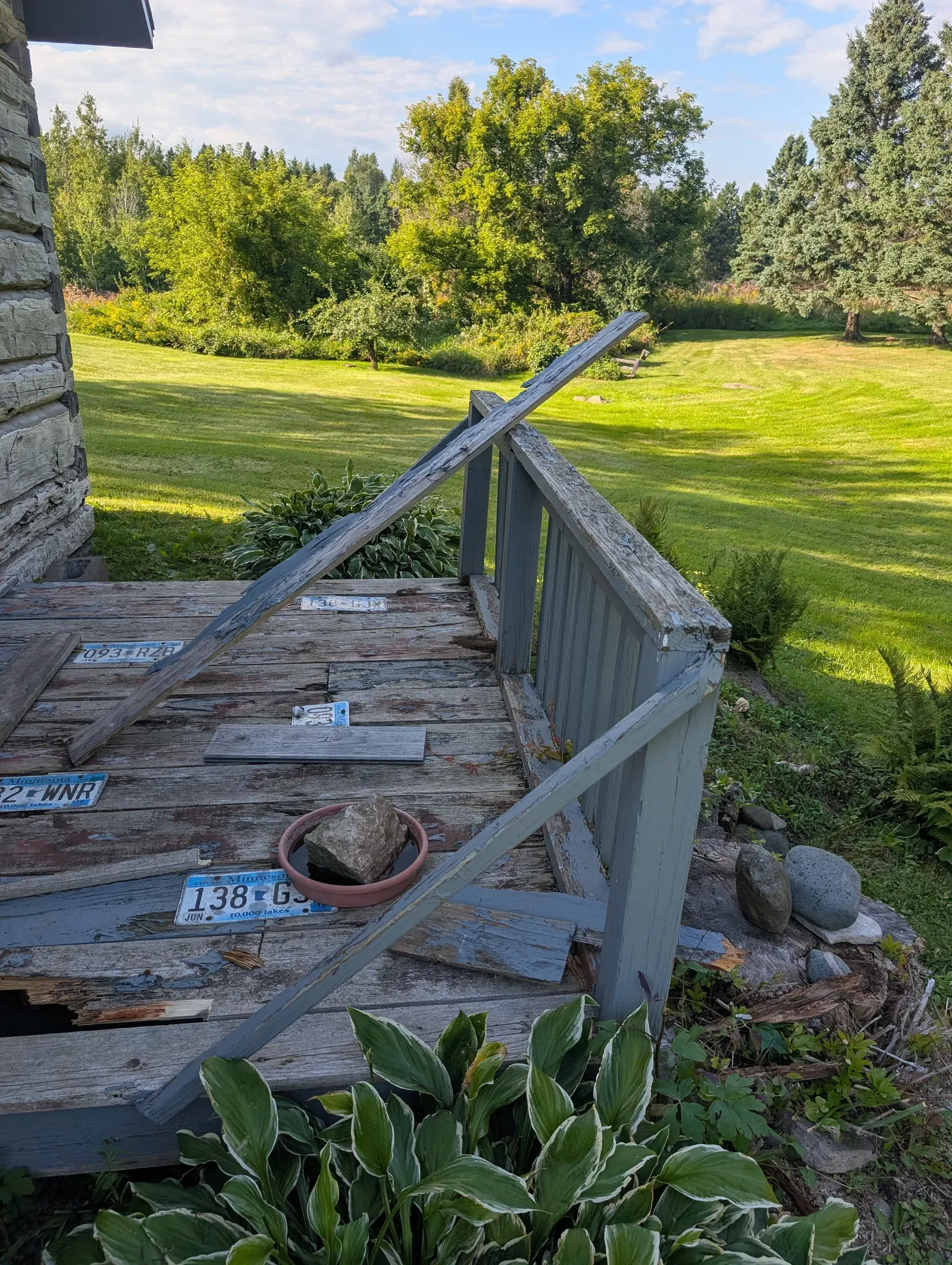 Original deteriorated deck in Hermantown with rotted boards and collapsed railing