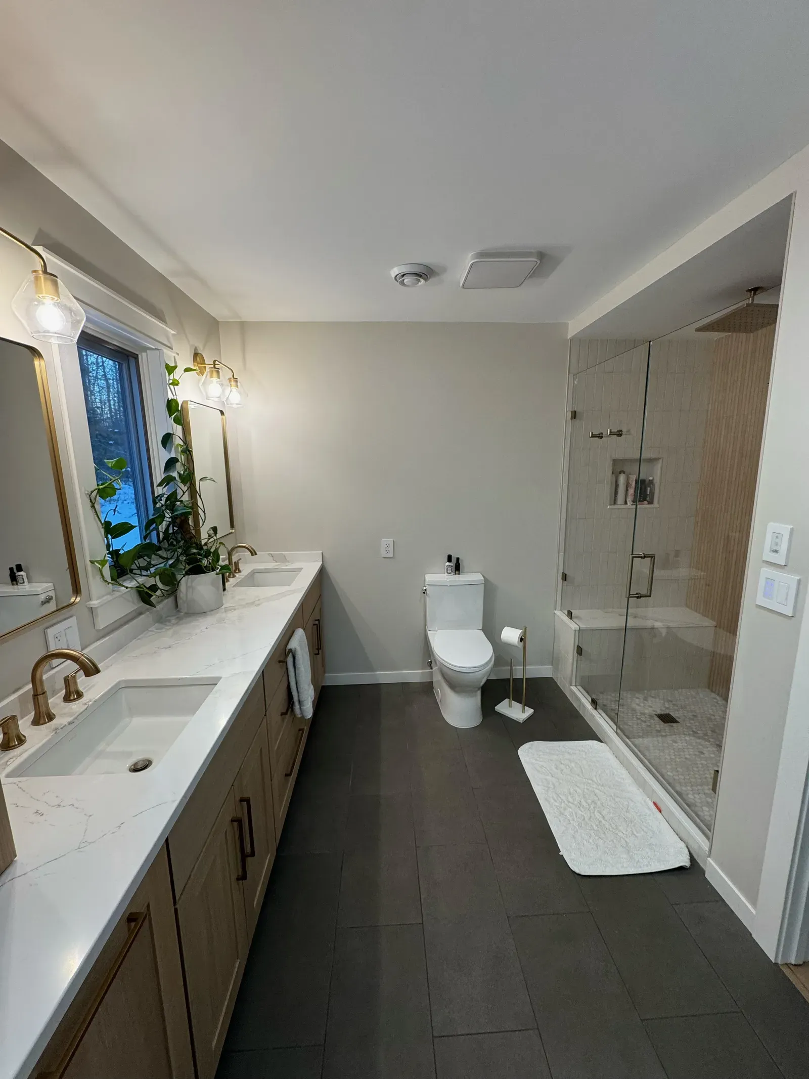 Renovated master bathroom with walk-in shower, double vanity, and modern fixtures