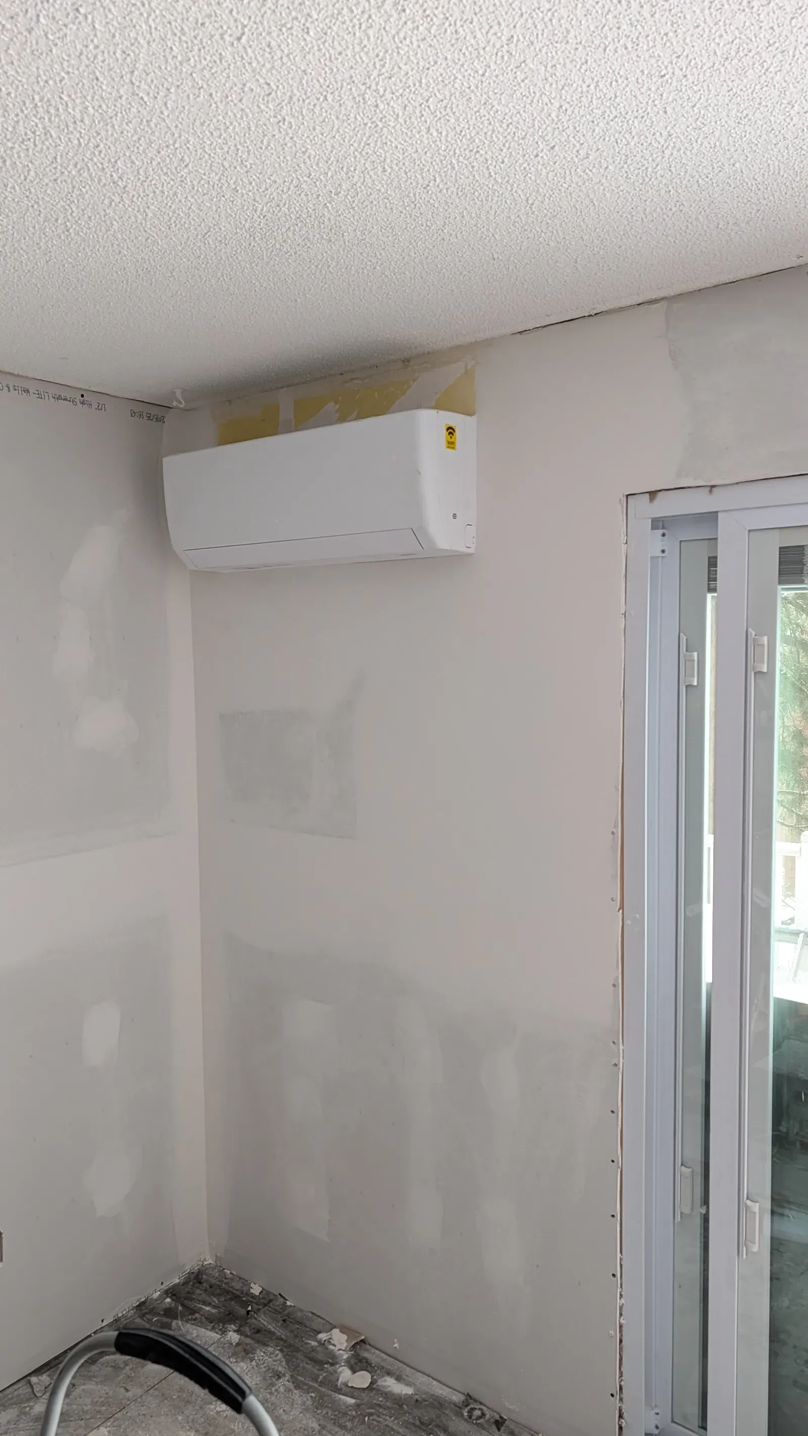 Drywall with mini-split installed, mudding and taping visible